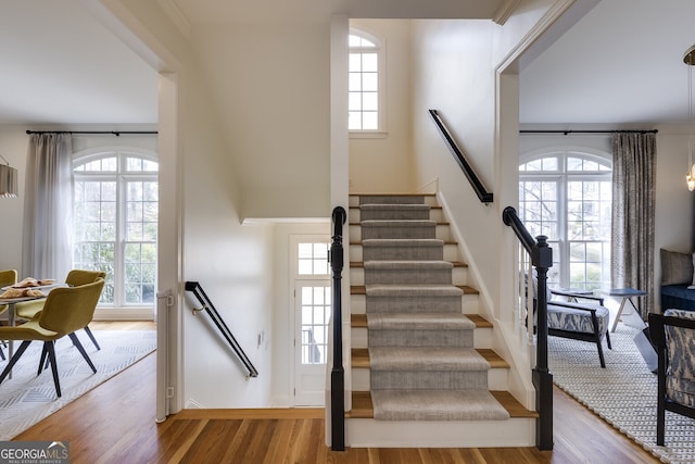 stairs with a wealth of natural light and wood finished floors