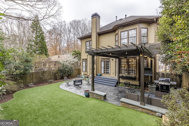 back of property with a fenced backyard, a chimney, a lawn, and a patio