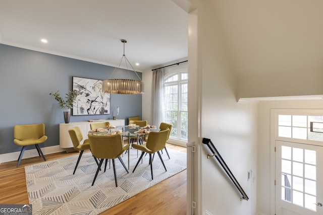 dining room featuring a chandelier, light wood-style flooring, recessed lighting, baseboards, and ornamental molding