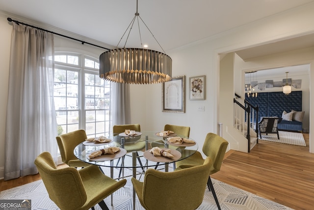 dining room with crown molding, stairs, and wood finished floors