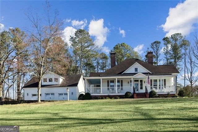 view of front facade with a porch, a front yard, and a garage