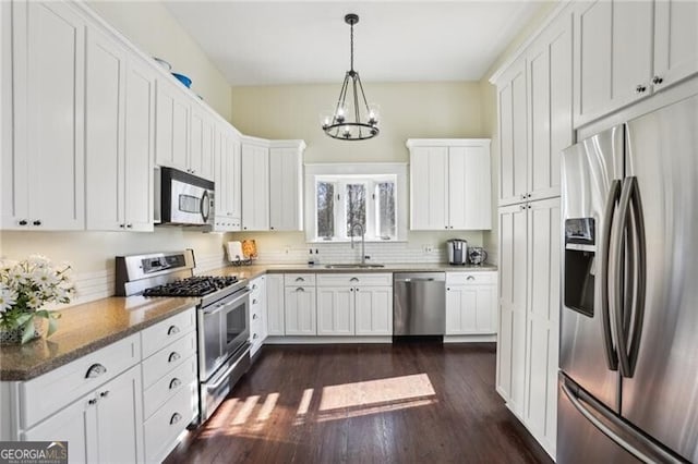 kitchen with stainless steel appliances, a sink, and white cabinetry