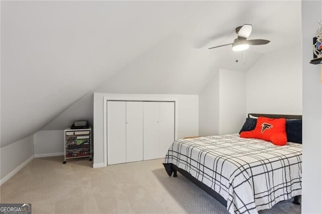 carpeted bedroom featuring lofted ceiling, a closet, ceiling fan, and baseboards