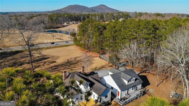 drone / aerial view featuring a mountain view and a view of trees