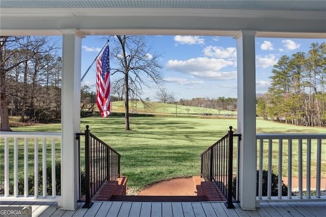 wooden terrace featuring covered porch and a yard