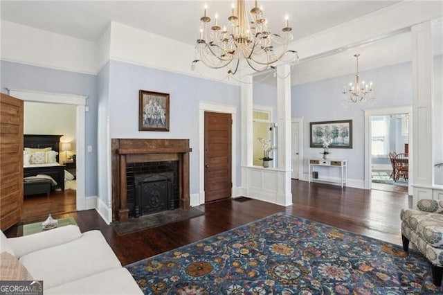 living room featuring an inviting chandelier, a fireplace with flush hearth, baseboards, and wood finished floors