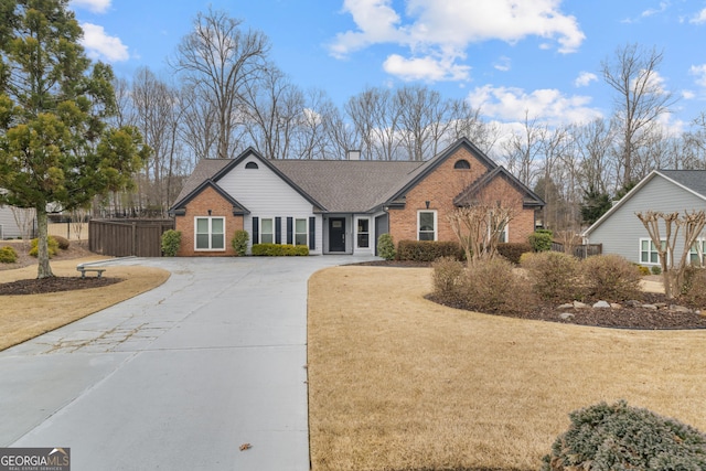 view of front of home with concrete driveway, brick siding, and a front lawn