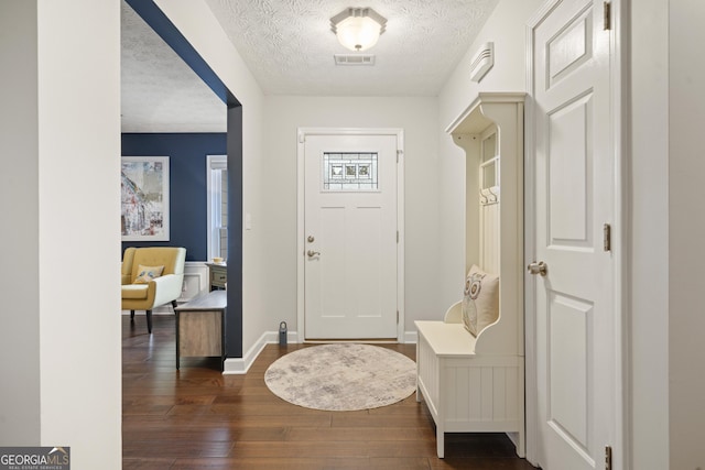 entryway featuring dark wood-style floors, visible vents, a textured ceiling, and baseboards