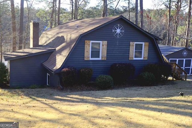 view of home's exterior featuring a chimney and a gambrel roof