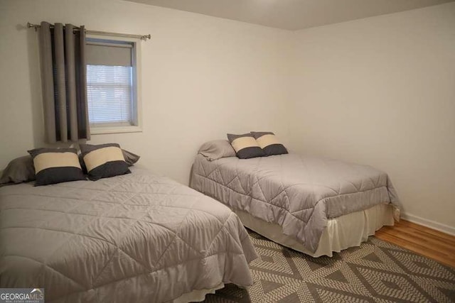 bedroom featuring baseboards and wood finished floors