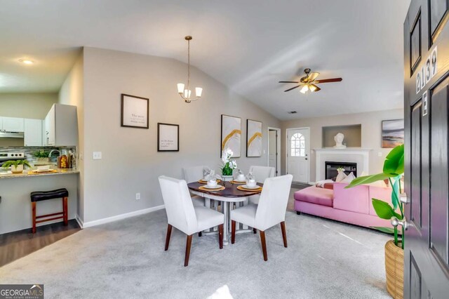 2139 Hickory Bnd SE Unit E, Conyers, GA 30013 - dining room with lofted ceiling, ceiling fan, carpet, a chandelier, and a glass covered fireplace