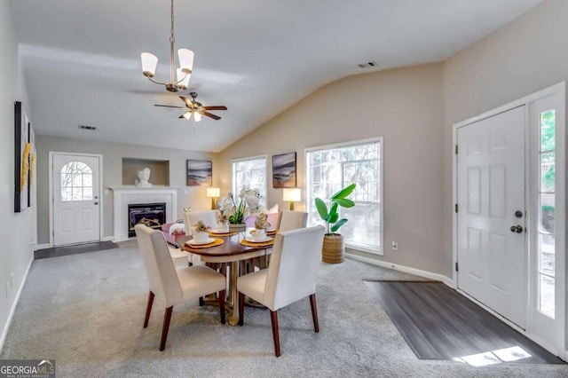 2139 Hickory Bnd SE Unit E, Conyers, GA 30013 - carpeted dining space with lofted ceiling, a fireplace with flush hearth, ceiling fan, and a chandelier
