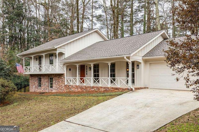 split level home featuring covered porch, a garage, concrete driveway, roof with shingles, and board and batten siding