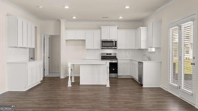 1069 Blue Juniper Cir, Loganville, GA 30052 - kitchen with stainless steel appliances, ornamental molding, dark wood-style flooring, and white cabinets