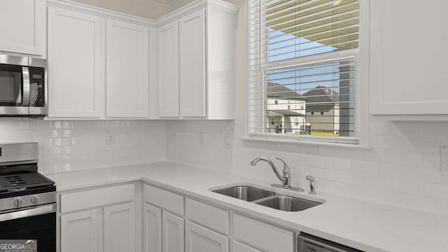 1069 Blue Juniper Cir, Loganville, GA 30052 - kitchen featuring stainless steel appliances, backsplash, a sink, and white cabinets