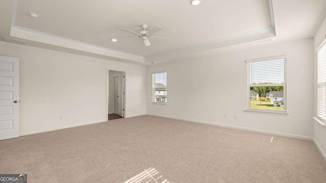 1069 Blue Juniper Cir, Loganville, GA 30052 - empty room with ceiling fan, a tray ceiling, carpet flooring, and baseboards