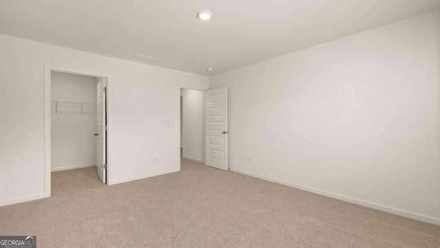 1069 Blue Juniper Cir, Loganville, GA 30052 - unfurnished bedroom featuring a closet, light carpet, a spacious closet, and baseboards