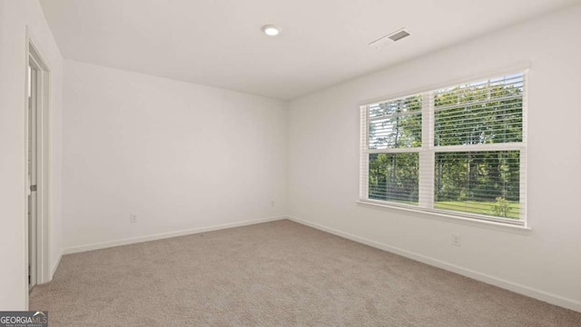 1069 Blue Juniper Cir, Loganville, GA 30052 - spare room featuring visible vents, light carpet, and baseboards