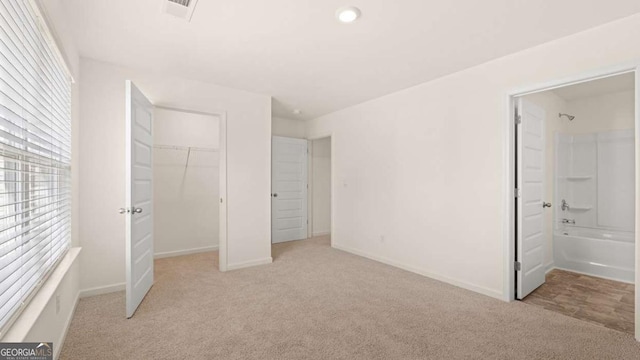 1069 Blue Juniper Cir, Loganville, GA 30052 - unfurnished bedroom with a closet, visible vents, light carpet, connected bathroom, and baseboards
