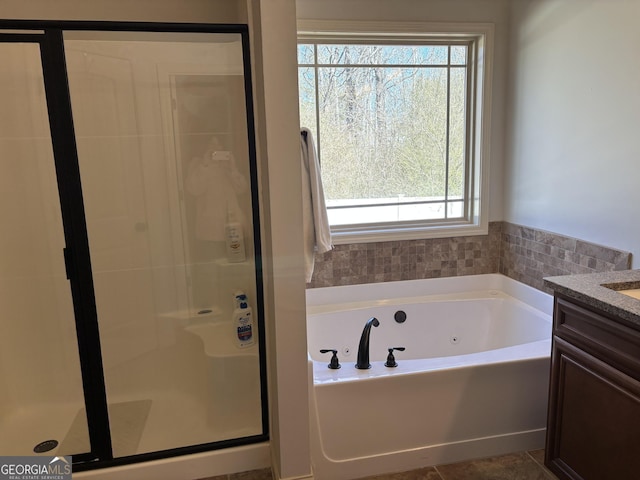 full bathroom featuring a whirlpool tub, a stall shower, vanity, and tile patterned floors