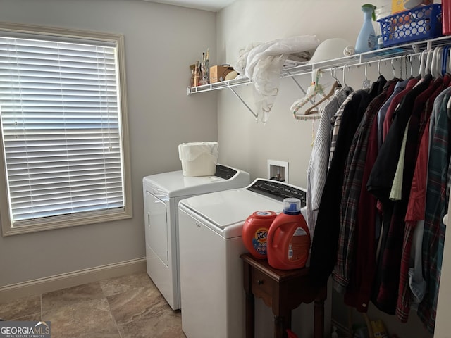 laundry room featuring laundry area, baseboards, and washing machine and clothes dryer