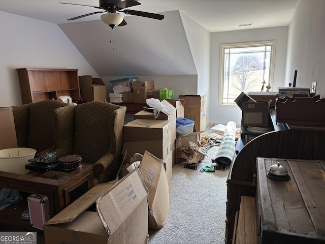 interior space featuring lofted ceiling, carpet, visible vents, and a ceiling fan