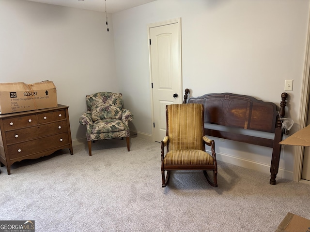 living area featuring carpet flooring and baseboards