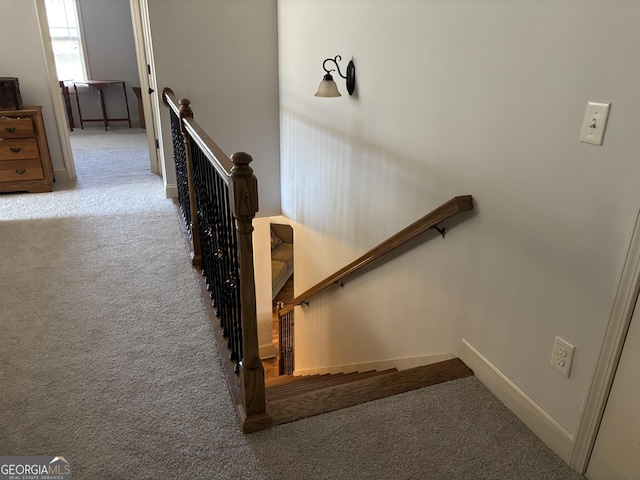 staircase featuring carpet and baseboards