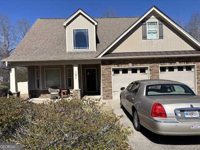 view of front of house featuring a garage, covered porch, metal roof, and a standing seam roof