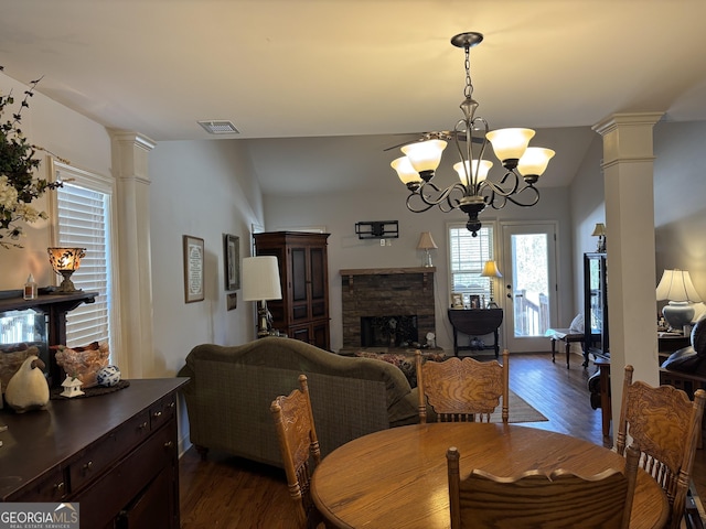 dining area featuring ornate columns, a fireplace, visible vents, and dark wood finished floors