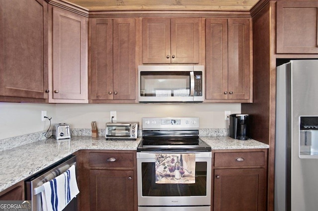 kitchen featuring appliances with stainless steel finishes, brown cabinets, light stone countertops, and a toaster