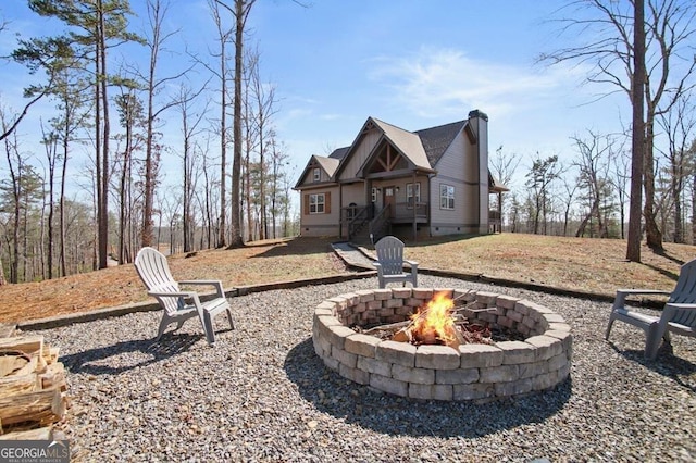 back of house featuring a fire pit, crawl space, and a chimney