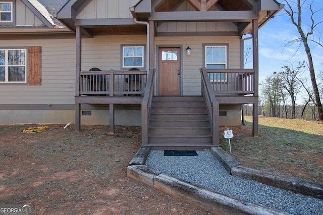 view of exterior entry featuring crawl space and board and batten siding