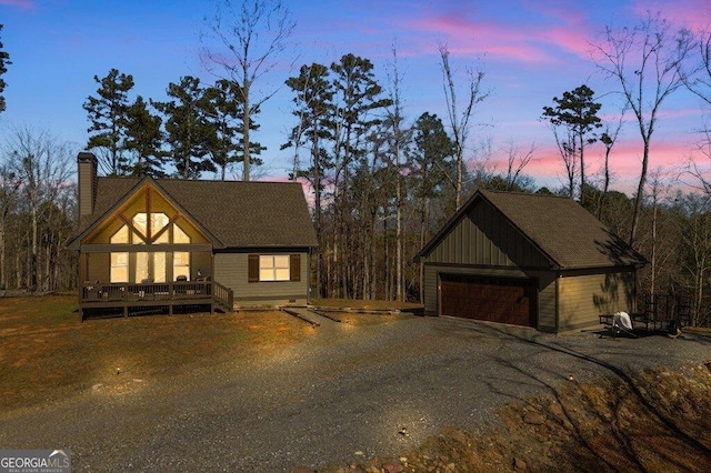 view of front of property with a garage, a chimney, and a wooden deck