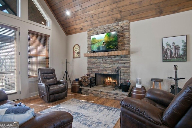 living area with high vaulted ceiling, wooden ceiling, a fireplace, and wood finished floors