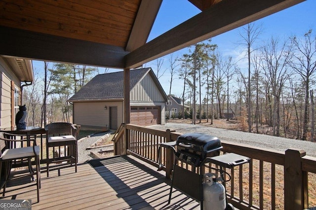 wooden terrace featuring a detached garage and an outdoor structure