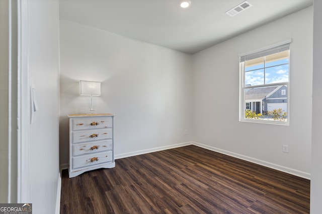 unfurnished bedroom with baseboards, visible vents, and dark wood-type flooring