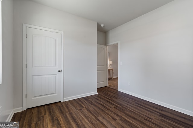 unfurnished bedroom featuring dark wood-style flooring and baseboards