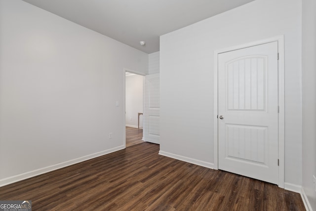 unfurnished bedroom featuring dark wood-style floors and baseboards