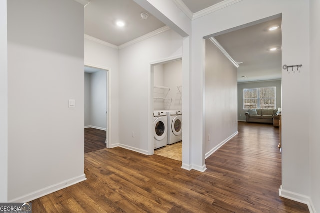 laundry room with wood finished floors, ornamental molding, and washing machine and clothes dryer