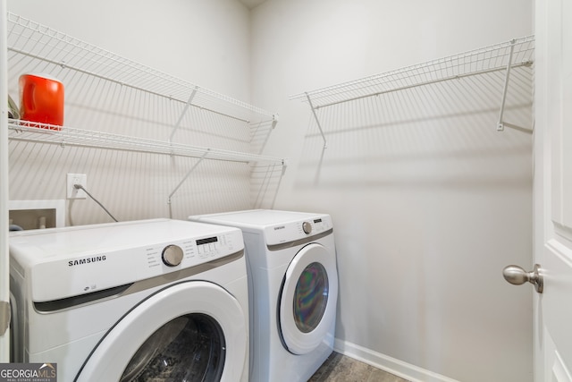 clothes washing area featuring wood finished floors, laundry area, baseboards, and separate washer and dryer