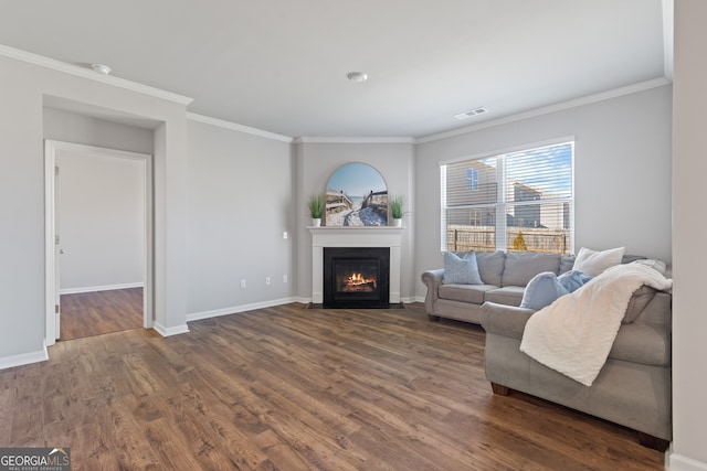 living area with dark wood-style floors, a fireplace with flush hearth, visible vents, and crown molding