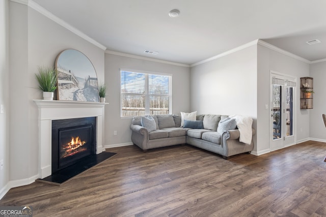 living room with baseboards, visible vents, a glass covered fireplace, dark wood-style floors, and crown molding