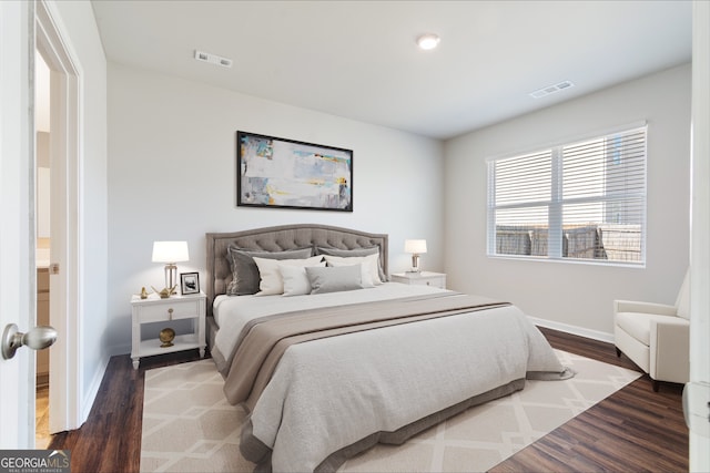 bedroom featuring wood finished floors, visible vents, and baseboards