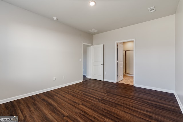 unfurnished bedroom with wood finished floors, visible vents, and baseboards