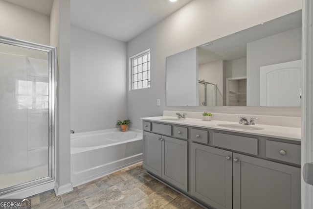 full bathroom featuring a stall shower, double vanity, a sink, and a bath