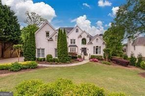 french country inspired facade with a front lawn