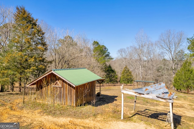 view of outdoor structure featuring a wooded view and an outdoor structure