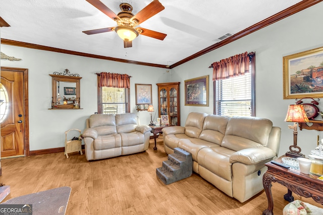 living room featuring ornamental molding, plenty of natural light, visible vents, and light wood-style floors