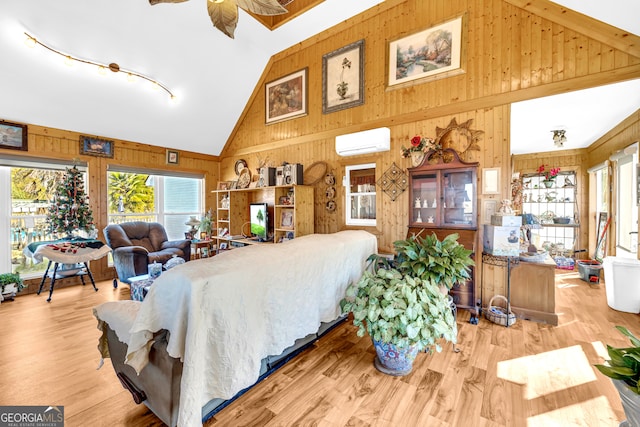 bedroom with an AC wall unit, wood walls, and wood finished floors